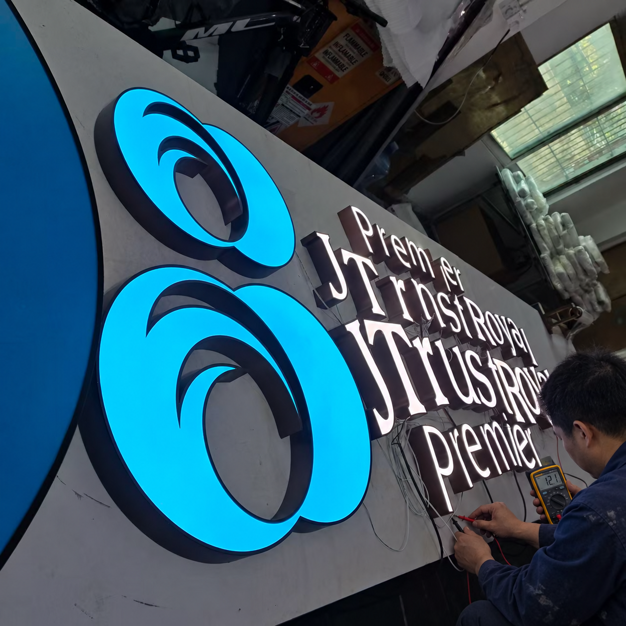 RBS technician performing electrical quality testing on illuminated custom signage