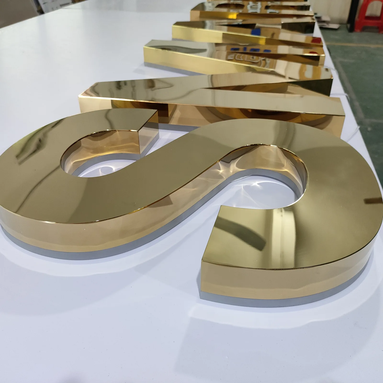 Side profile of a mirror gold stainless steel backlit letter