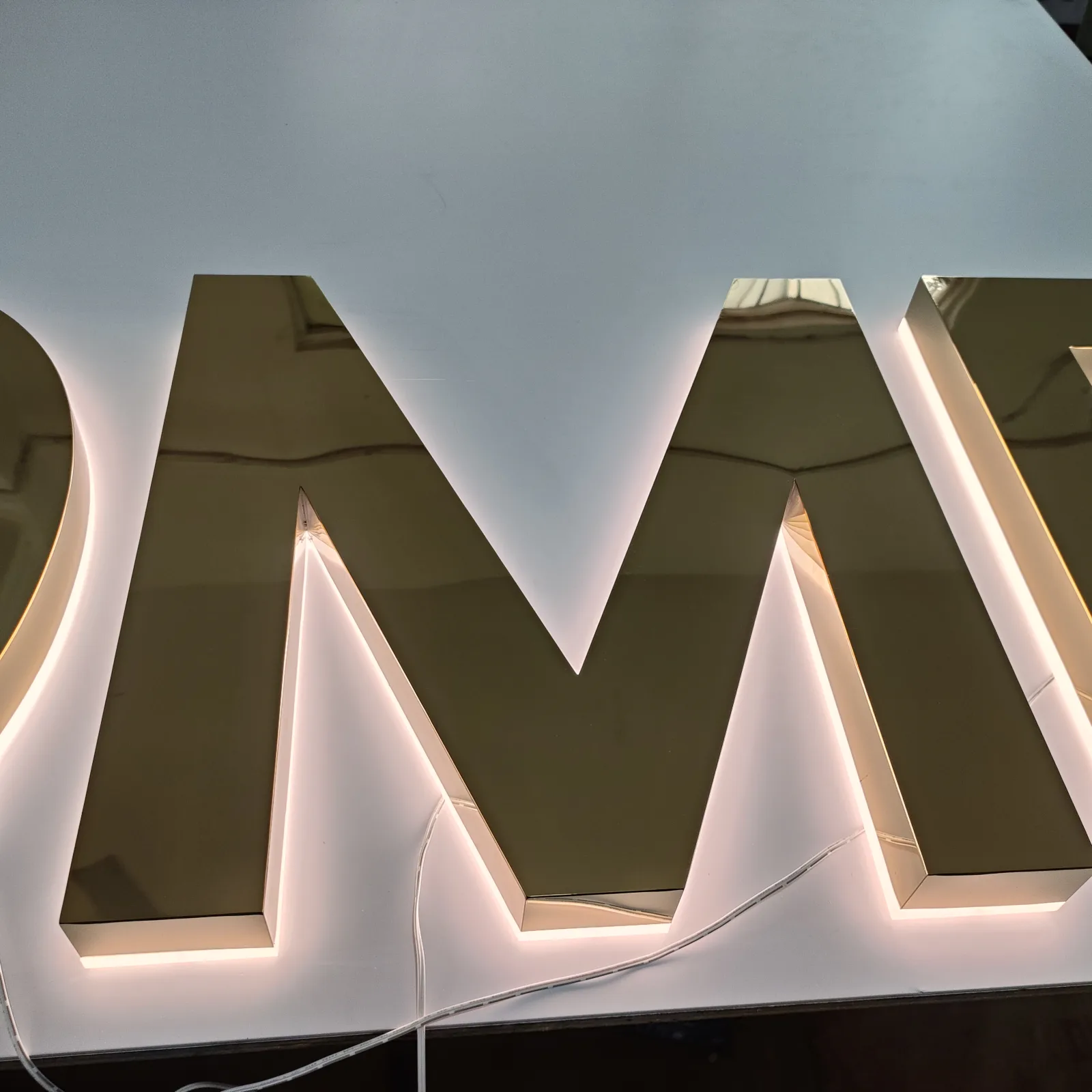 Illuminated mirror gold storefront letter detail