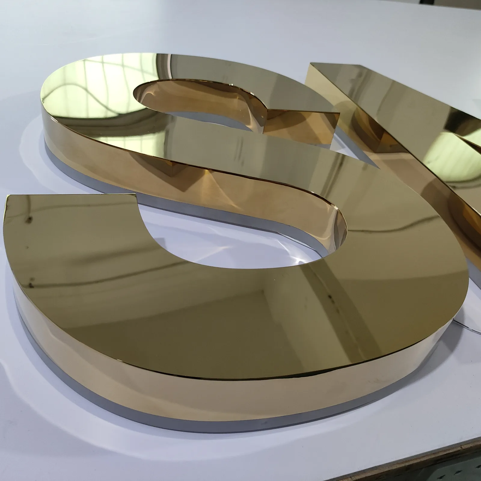 Polished titanium gold finish on a custom sign letter