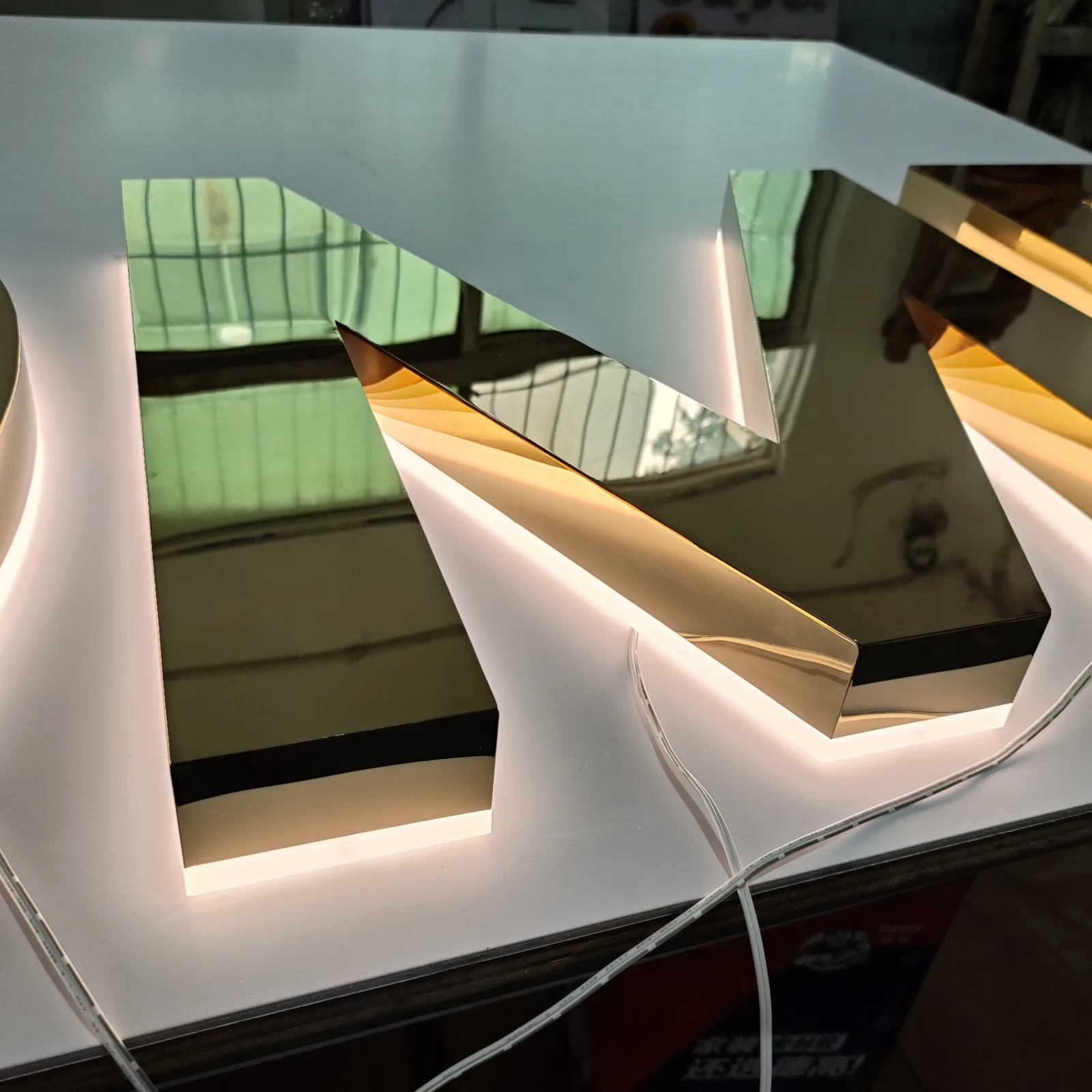 3500K warm white halo illumination on a mirror gold stainless steel letter
